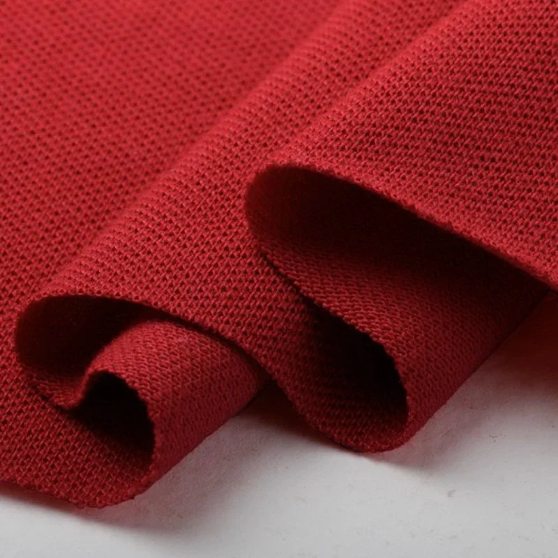 Gros plan sur le piqué de coton uni au mètre de Longan Craft France, un tissu jersey tricoté idéal pour les polos ou le bricolage, présenté drapé et légèrement plié sur du blanc - parfait pour les chemises.