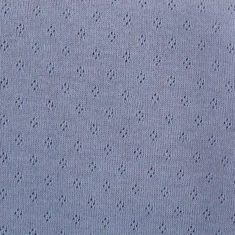 Gros plan sur le tissu bleu clair Tissu jersey pointelle 100% coton au mètre de Longan Craft France, un tissu jacquard pointelle avec un motif répété de petits diamants ajourés - parfait pour les bodys de bébé DIY.