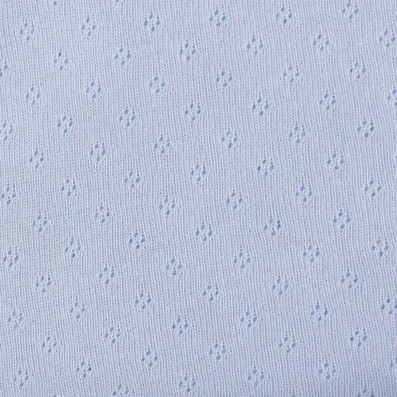 Gros plan sur le Tissu jersey pointelle 100% coton de Longan Craft France, un tissu jacquard bleu clair avec un petit motif ajouré en forme de losange - parfait pour un body bébé doux et respirant ou d'autres créations délicates.