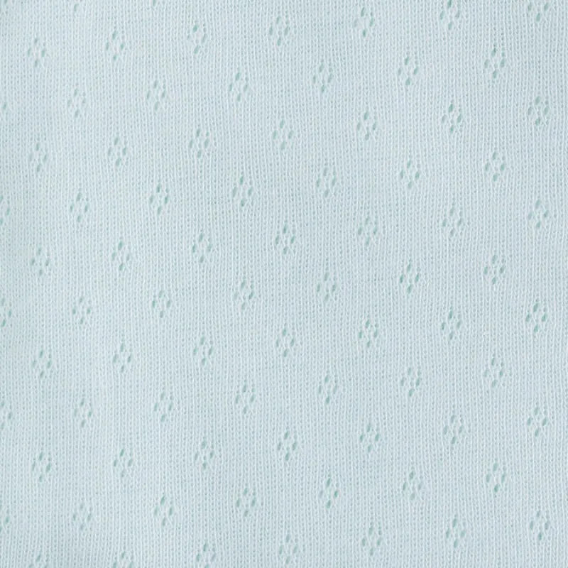 Gros plan sur le tissu bleu clair Tissu jersey pointelle 100 % coton de Longan Craft France, montrant son motif jacquard avec de petits trous en forme de losange - un tissu idéal pour le bricolage, pour les bodys de bébé et les projets légers au mètre.