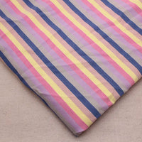 Un morceau de Longan Craft France Tissu French Terry extensible à rayures arc-en-ciel, présentant des rayures verticales bleues, roses, jaunes et lavande, repose sur une surface beige unie.