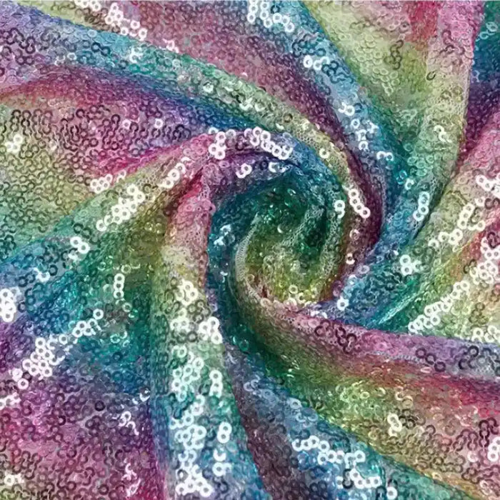 Gros plan sur le Tissu sequin arc-en-ciel au mètre de Longan Craft France, un tissu irisé étincelant avec des paillettes multicolores aux motifs tourbillonnants, idéal pour les tenues de soirée et les projets créatifs.