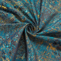 Gros plan sur Tissu brocart vert rétro au mètre de Longan Craft France, un tissu d'ameublement jacquard aux accents métalliques dorés et aux plis tourbillonnants dans des motifs marbrés bleu sarcelle, or et marron foncé.