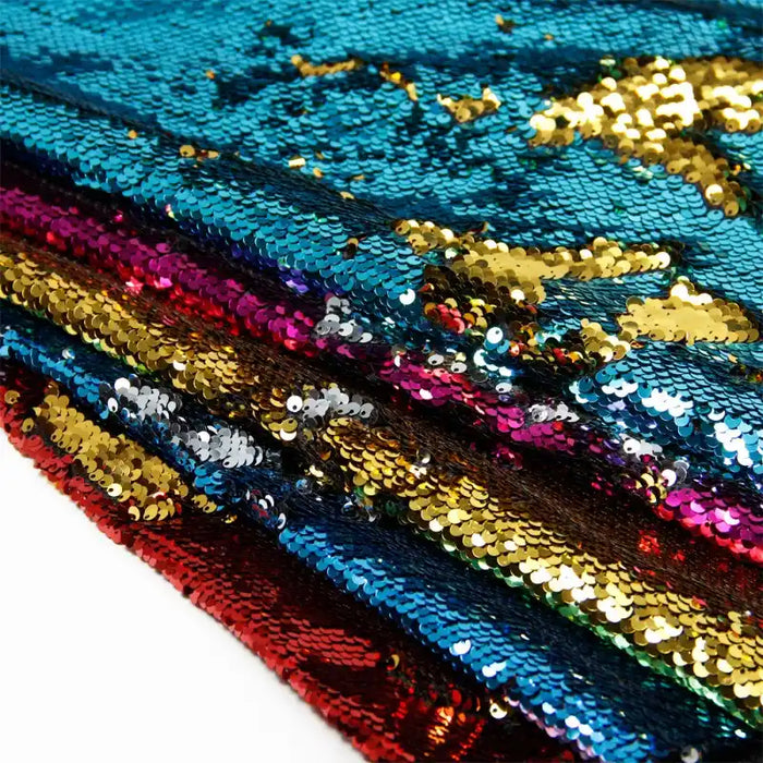 Un gros plan du tissu à paillettes réversible bicolore de Longan Craft France montre sa surface brillante et texturée, idéale pour les accessoires. Disponible en bleu, rouge, or et rose. Tissu pailleté réversible vendu au mètre.