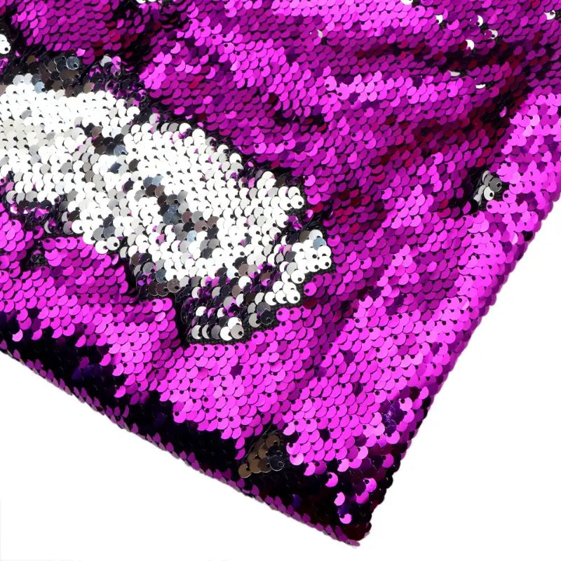 Un gros plan du Tissu pailleté bicolore réversible au mètre de Longan Craft France montre des paillettes roses et blanches brillantes, partiellement brossées pour révéler les deux couleurs, créant un effet irisé et réfléchissant - parfait pour des accessoires étincelants.