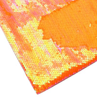 Gros plan sur le tissu pailleté bicolore réversible au mètre de Longan Craft France, qui présente de petites paillettes orange brillantes au fini irisé. La vue à plat met en valeur la texture chatoyante unique de cette matière scintillante idéale pour accessoires.