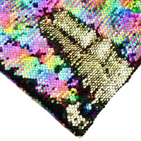 Gros plan sur un oreiller carré en tissu pailleté bicolore réversible au mètre de Longan Craft France, avec un pouce levé en paillettes dorées sur des paillettes réversibles multicolores.