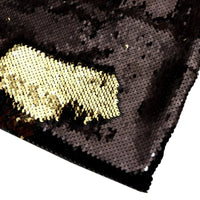 Un gros plan du tissu pailleté bicolore réversible au mètre de Longan Craft France montre principalement des paillettes noires, avec une section brossée révélant un dessous doré - une matière scintillante idéale pour les accessoires.
