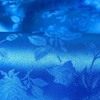 Découvrez le Tissu satin jacquard rose au mètre de Longan Craft France : un jacquard polyester lisse bleu vif avec des motifs floraux tissés et brillants, parfait pour la couture et reflétant magnifiquement la lumière.