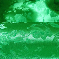 Un gros plan sur le Tissu satin jacquard rose au mètre de Longan Craft France montre sa surface réfléchissante à motifs floraux, idéale comme textile satiné à motifs floraux pour la confection de peignoirs.