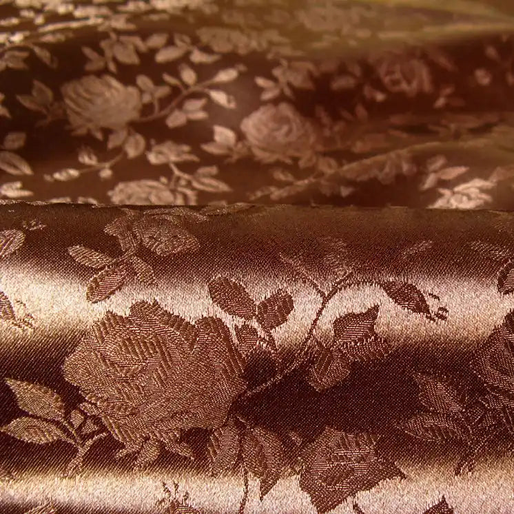 Découvrez le Tissu satin jacquard rose au mètre de Longan Craft France : un tissu polyester marron brillant avec un motif floral complexe en relief, idéal pour confectionner des robes élégantes.