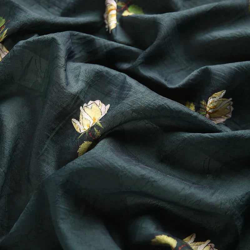 Tissu lyocell imprimé roses au mètre de Longan Craft France : textile en lyocell brodé motif floral, respirant et idéal pour la confection de robes. Motif de fleurs jaunes et blanches sur fond vert avec texture subtile.