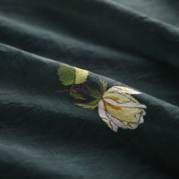 Gros plan sur le Tissu lyocell imprimé roses au mètre de Longan Craft France, montrant sa texture subtile et son motif floral brodé sur un lyocell respirant, parfait pour la confection de robes.