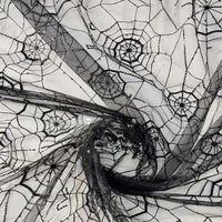 Le tissu en tulle brodé de paillettes au mètre de Longan Craft France, qui présente un motif de toile d'araignée transparente, ajoute une touche effrayante à l'Halloween. Le tissu transparent révèle la surface en dessous et est parfait pour les décorations festives.
