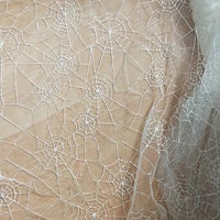 Le Tissu en tulle brodé de sequins au mètre de Longan Craft France, avec son délicat motif de toile d'araignée, crée un effet de superposition et de translucidité, idéal pour les décorations d'Halloween.