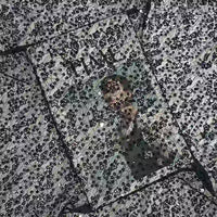 Une couverture de magazine Time, partiellement cachée par des gouttes d'eau sur le verre, prend un effet texturé et flou - rappelant le chatoiement et la complexité du Tissu dentelle à paillettes au mètre de Longan Craft France pour les robes de mariée.