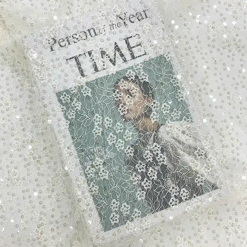 Une couverture du magazine Time intitulée "Person of the Year", représentant une personne en blanc, est partiellement ornée de tissu dentelle à paillettes au mètre de Longan Craft France, pour un éclat élégant et accrocheur, parfait pour les robes de mariée ou les vêtements.