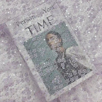 Une couverture du magazine TIME représentant une personne est élégamment recouverte du "Tissu dentelle à sequins au mètre | Dentelle pailletée pour robes de mariée" de Longan Craft France, ajoutant une texture étincelante au titre "Personne de l'année".