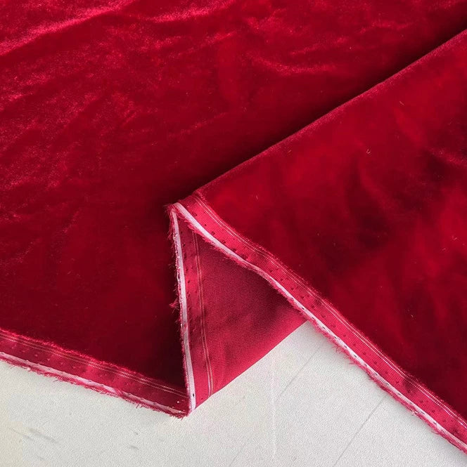 Un gros plan de Tissu velours de soie au mètre de Longan Craft France montre sa texture douce de soie de mûrier avec un bord plié révélant le dessous - idéal pour les robes de chambre, la couture, l'artisanat et la tapisserie haut de gamme.