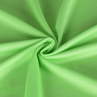 Gros plan sur le tissu piqué uni simple face au mètre de Longan Craft France, une maille fine d'été vert clair idéale pour les chemises à manches courtes DIY, froncée en spirale pour mettre en valeur sa texture lisse et ses plis subtils.