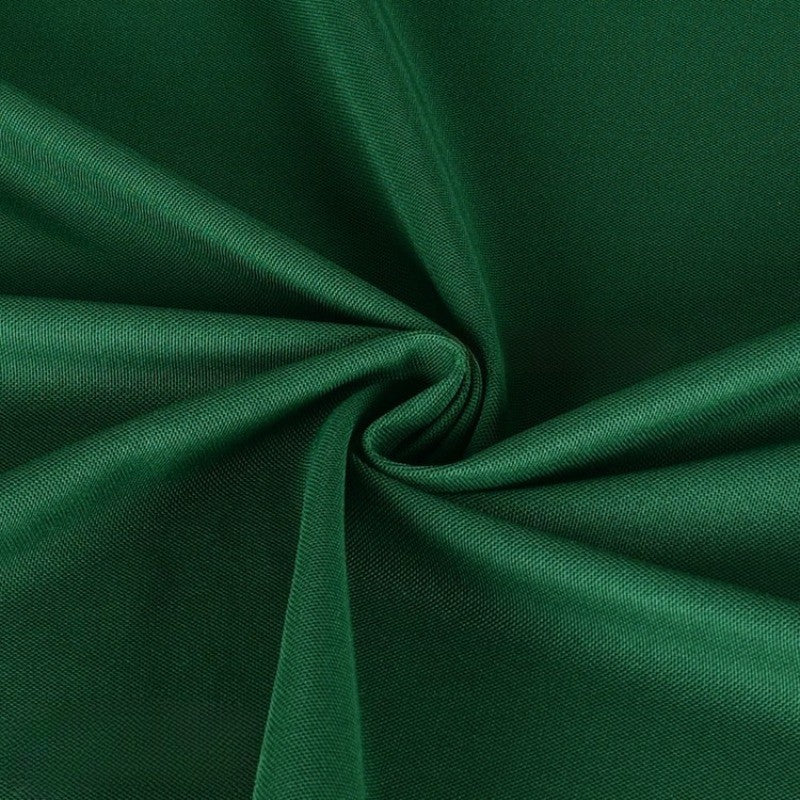 Gros plan sur le Tissu piqué uni simple face au mètre de Longan Craft France, qui présente une fine maille piqué d'été vert foncé avec une texture lisse arrangée en plis souples - idéal pour confectionner des chemises à manches courtes.