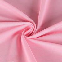 Gros plan sur Longan Craft France Tissu piqué uni simple face au mètre, une maille piqué fine d'été rose pâle, montrant sa texture délicate en mesh et ses plis torsadés, idéale pour chemises manches courtes à coudre DIY.