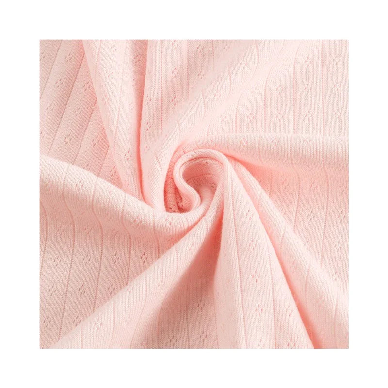 Découvrez le Tissu jersey pointelle coton simple face au mètre de Longan Craft France - un tissu côtelé rose pâle et doux au motif subtilement texturé, idéal pour confectionner des bodys pour bébé ou des pyjamas douillets.