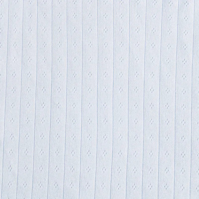 Le Tissu jersey pointelle coton simple face de Longan Craft France est un tissu de coton bleu clair à maille unique, avec des côtes verticales et des petites perforations en forme de losange, idéal pour confectionner des bodys et des pyjamas pour bébé.