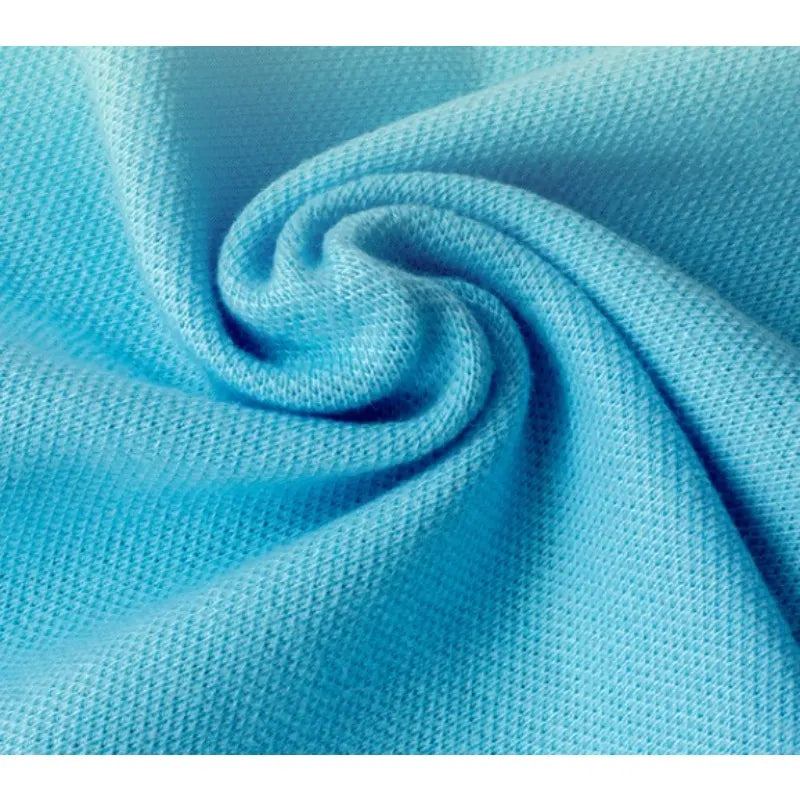 Gros plan sur le tissu piqué bleu clair motif œil d'oiseau à fil simple de Longan Craft France, qui présente un tissage finement texturé et un motif en spirale - idéal pour les polos et T-shirts d'été DIY respirants.