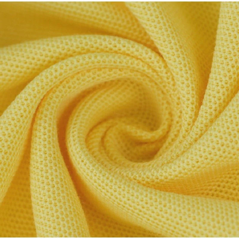 Gros plan sur le Tissu piqué motif œil d'oiseau à fil simple de Longan Craft France : ce tissu jaune respirant présente une torsion en spirale, avec le tissage caractéristique de l'œil d'oiseau créant de petits trous régulièrement espacés pour les polos et les T-shirts d'été.