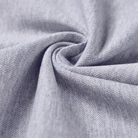 Gros plan sur le tissu piqué motif œil d'oiseau à fil simple de Longan Craft France, torsadé pour mettre en valeur sa maille respirante et sa souplesse, idéale pour les polos et T-shirts d'été DIY.