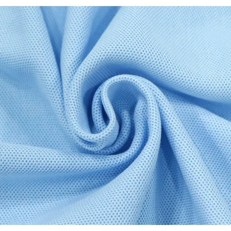 Gros plan sur le Tissu piqué motif œil d'oiseau à fil simple de Longan Craft France, qui présente une maille douce et respirante avec des trous régulièrement espacés - un tissu de bricolage idéal au mètre pour les polos et les T-shirts d'été.