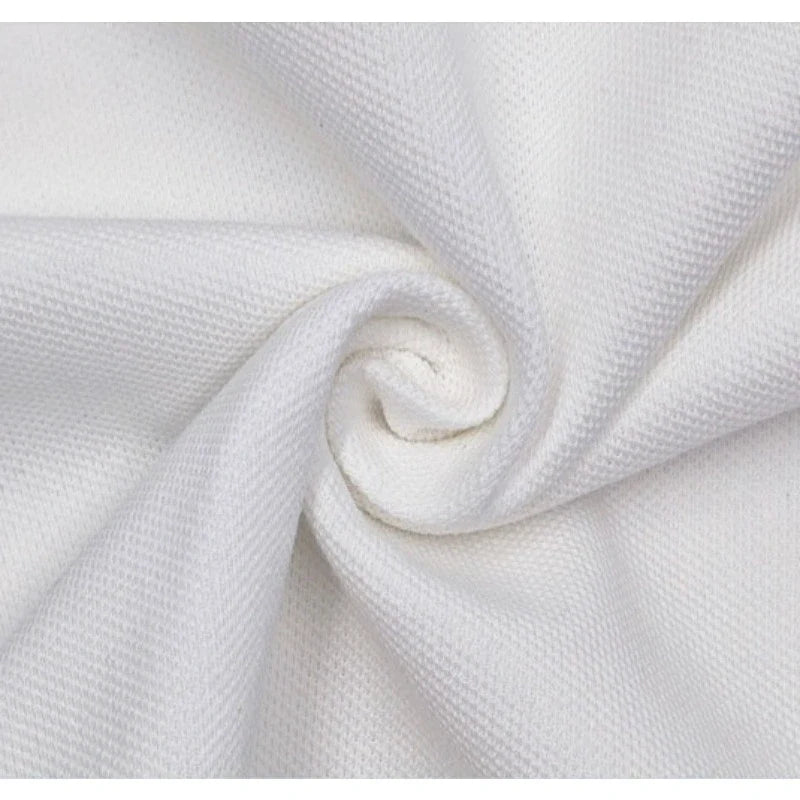 Gros plan sur le tissu piqué motif œil d'oiseau à fil simple au mètre de Longan Craft France, torsadé pour révéler la texture et le tissage respirant - un tissu de bricolage idéal pour les polos et les T-shirts d'été.