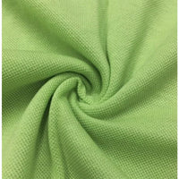 Un gros plan sur le tissu piqué motif œil d'oiseau à fil simple au mètre de Longan Craft France montre le tissage et la texture respirante de l'œil d'oiseau, idéal pour les polos et les T-shirts d'été DIY.