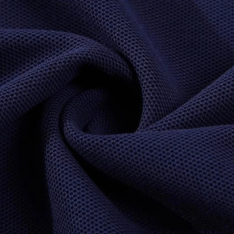 Gros plan sur le Tissu piqué motif œil d'oiseau à fil simple bleu foncé de Longan Craft France, dont le tissage respirant et texturé est torsadé en spirale - un tissu idéal pour le bricolage estival, vendu au mètre, pour les polos et les T-shirts.