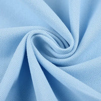 Gros plan sur le tissu piqué bleu clair motif œil d'oiseau à fil simple de Longan Craft France, disposé en tourbillon pour mettre en valeur sa maille respirante et son tissage texturé - idéal pour les polos et les T-shirts DIY de l'été.