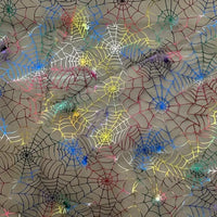 La toile d'araignée au mètre en organza coloré et extensible de Longan Craft France décore un fond neutre avec des toiles d'araignée d'Halloween qui se chevauchent. Des araignées en plastique assorties complètent ce look festif et créatif pour les costumes ou les travaux manuels.
