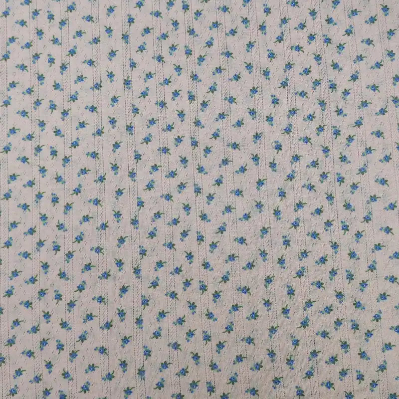 Découvrez le tissu pointelle à petites fleurs de Longan Craft France : maille légère imprimée d'été, idéale au mètre pour coudre des robes et vestes d'enfants, motif floral frais sur fond clair, parfait pour vos créations DIY.