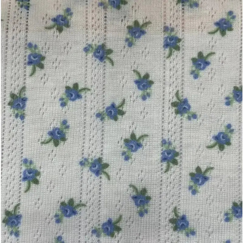 Tissu pointelle à petites fleurs au mètre de Longan Craft France : maille légère d'été, parfait pour la couture DIY de robes et vestes enfants, motif floral bleu et vert avec rayures façon dentelle.