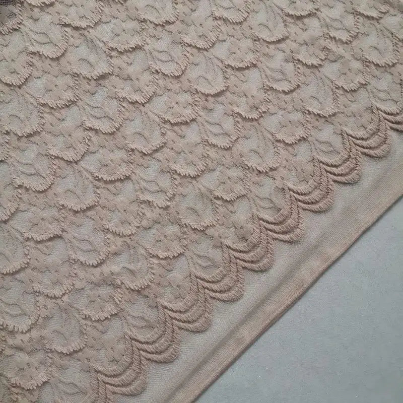 Un gros plan de la dentelle extensible au mètre de Longan Craft France révèle des franges florales complexes et des textures douces, mettant en valeur l'élégance de cette dentelle brodée pour les robes de bricolage et la lingerie.