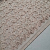 Un gros plan de la dentelle extensible au mètre de Longan Craft France révèle des franges florales complexes et des textures douces, mettant en valeur l'élégance de cette dentelle brodée pour les robes de bricolage et la lingerie.