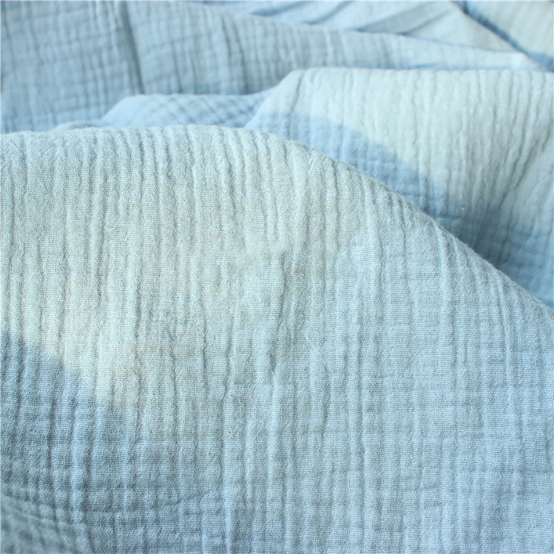Gros plan sur le Tissu double gaze doux au mètre bleu clair de Longan Craft France, qui présente un motif texturé en forme de grille. Ce tissu léger offre une douceur exceptionnelle, idéale pour les vêtements de bébé.