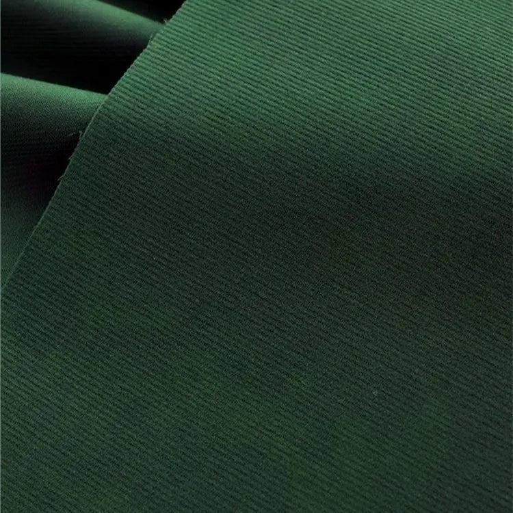 Un gros plan du Tissu velours côtelé uni 21 côtes au mètre de Longan Craft France montre son tissu de coton vert foncé avec de fines nervures et une finition lisse, ainsi qu'un pli visible dans le coin supérieur gauche.