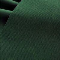 Un gros plan du Tissu velours côtelé uni 21 côtes au mètre de Longan Craft France montre son tissu de coton vert foncé avec de fines nervures et une finition lisse, ainsi qu'un pli visible dans le coin supérieur gauche.