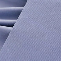 Gros plan sur le Tissu velours côtelé uni 21 côtes au mètre de Longan Craft France en bleu clair : fines nervures verticales en coton, texture douce, superposition soignée - idéal pour les vêtements et pantalons confortables.