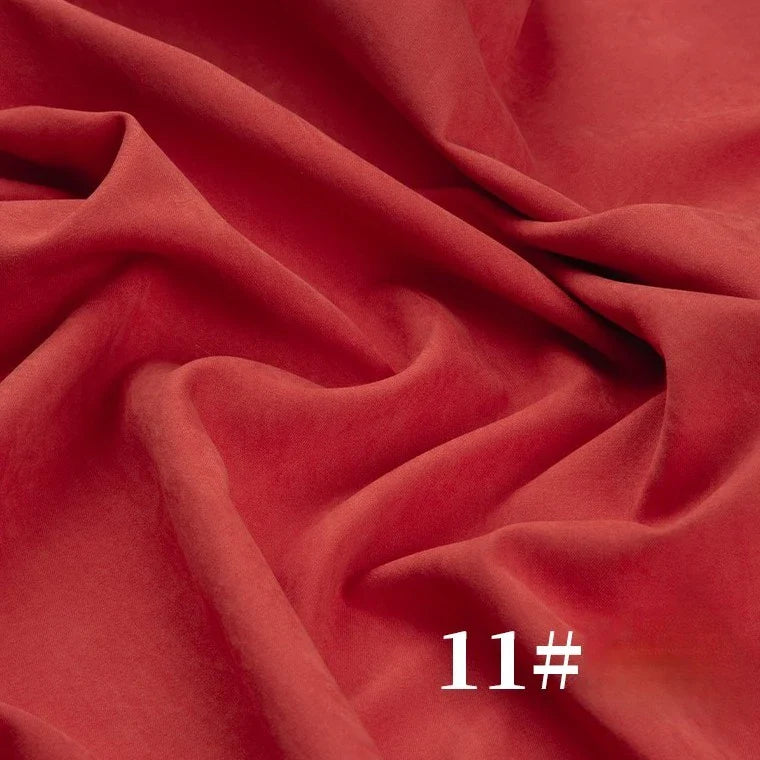Un gros plan de la peau de pêche rouge Microsuède polyester uni mi-épais au mètre de Longan Craft France montre des plis visibles, avec "11#" en texte blanc en bas à droite.