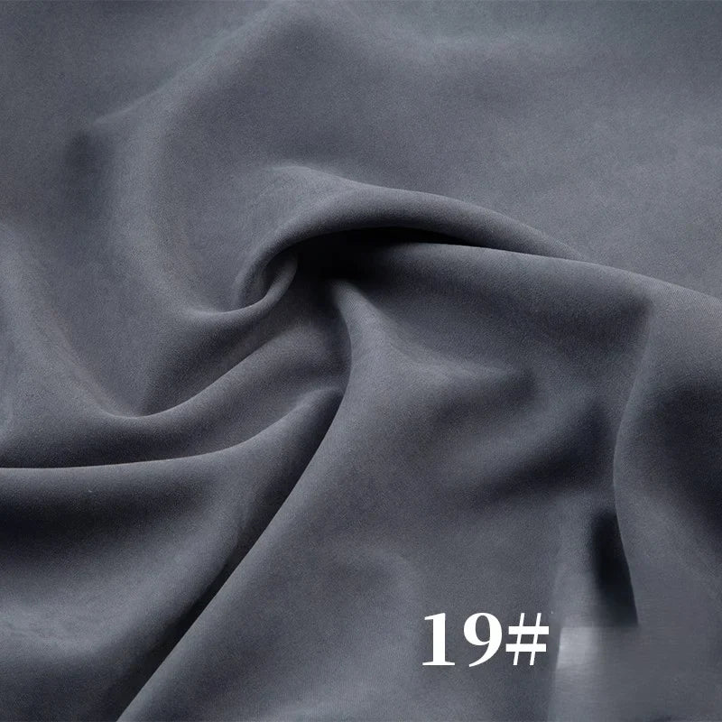 Un gros plan de la peau de pêche mi-épais microsuède polyester de Longan Craft France montre un tissu gris lisse à texture veloutée et léger éclat, idéal pour robes. Le numéro "19#" s'affiche en blanc en bas à droite de l'image.