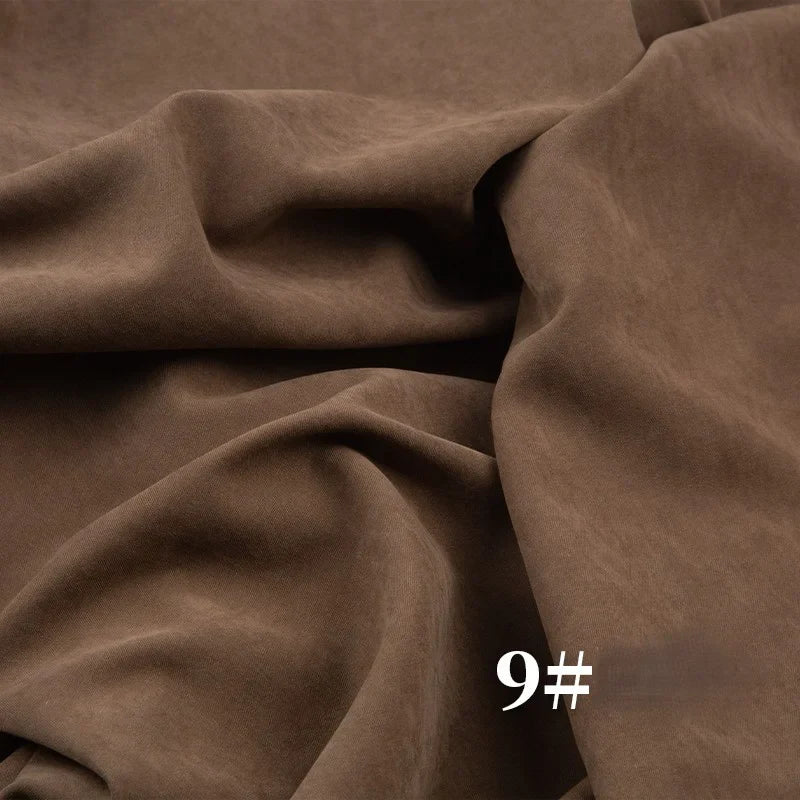 Un gros plan de Longan Craft France Microsuède polyester peau de pêche uni mi-épais montre un tissu brossé brun à texture veloutée, drapé et plié, avec le numéro "9#" imprimé en blanc en bas à droite. Idéal pour robes.