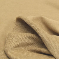 Gros plan sur le Tissu French Terry en coton uni au mètre de Longan Craft France, montrant sa couleur beige, son recto lisse et son verso texturé - un tissu épais idéal pour les sweatshirts et les sweats à capuche.