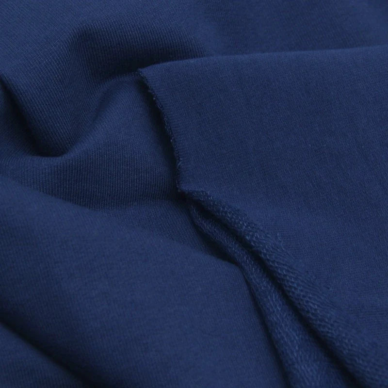 Gros plan sur le tissu de coton French Terry de Longan Craft France, de couleur bleu foncé, montrant sa texture lisse et ses bords nets, idéal pour les sweatshirts et les capuches épaisses.